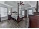 Bedroom with a four-poster bed, tray ceiling, wood floors, and ample natural light from the windows at 1012 Jubilee Way, Powder Springs, GA 30127