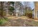 Private backyard featuring mature trees, a storage shed, and a stone pathway at 1042 Wildwood Wake Bnd, Dacula, GA 30019