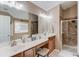 Bathroom featuring a double vanity, large mirrors, and a glass shower with tiled walls at 1042 Wildwood Wake Bnd, Dacula, GA 30019