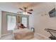 Bedroom with a large window, ceiling fan, and decorative vines and hanging lights at 1042 Wildwood Wake Bnd, Dacula, GA 30019