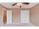 Neutral colored bedroom featuring a ceiling fan, large window, and a closet at 1042 Wildwood Wake Bnd, Dacula, GA 30019