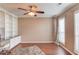 Home office with built-in shelves, hardwood floors, natural light, and a ceiling fan at 1042 Wildwood Wake Bnd, Dacula, GA 30019