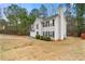 View of home showing the attached two-car garage, well-maintained lawn, and mature trees surrounding the property at 3999 Craggy Perch, Douglasville, GA 30135