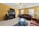 Living room featuring a fireplace, plush sofas, large windows that provide natural light, and modern ceiling fan at 3999 Craggy Perch, Douglasville, GA 30135