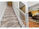 Carpeted staircase with white railings and a view of the living room with a fireplace at 3999 Craggy Perch, Douglasville, GA 30135