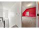 Upstairs hallway leading to a carpeted bedroom with a red accent wall and natural light at 3999 Craggy Perch, Douglasville, GA 30135