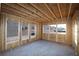 This bedroom is in the framing stage, showing studs, plywood, and window views at 436 Maypop Lane, Woodstock, GA 30188