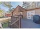 An elevated view of the home's wood deck, with a grill, outdoor access, and railing at 715 Wallington Way, Lawrenceville, GA 30046