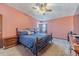 A bedroom featuring a ceiling fan, carpeted floor, and large window allowing ample lighting at 715 Wallington Way, Lawrenceville, GA 30046