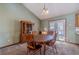 Charming dining area with wooden table, chairs, and views of the backyard through glass doors at 715 Wallington Way, Lawrenceville, GA 30046