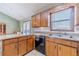 Well-lit kitchen featuring wooden cabinetry, stainless steel appliances, and a bright, window-filled dining area at 715 Wallington Way, Lawrenceville, GA 30046