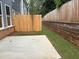 Partial view of backyard with patio and stone retaining wall with wooden fence for privacy and low maintenance at 1024 Rose Dr, Marietta, GA 30060
