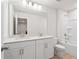 Well-lit bathroom with double vanity, large mirror, and white cabinets at 1024 Rose Dr, Marietta, GA 30060