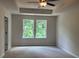 Spacious primary bedroom with a ceiling fan and bright windows overlooking lush greenery at 1024 Rose Dr, Marietta, GA 30060