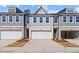 Attractive townhome with a light gray exterior, white garage doors, and coordinated landscaping for curb appeal at 1024 Rose Dr, Marietta, GA 30060