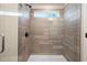 Modern tiled shower with glass door, dark fixtures, and a built-in shower head at 1024 Rose Dr, Marietta, GA 30060