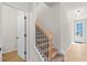 Inviting staircase with wooden treads, black iron balusters, and an open doorway leading to the home's entrance at 1024 Rose Dr, Marietta, GA 30060