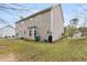 Rear exterior of the home with a well-kept lawn, vinyl siding, and mature trees at 1256 Melrose Forrest Ln, Lawrenceville, GA 30045