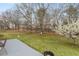 Expansive backyard with a patio, mature trees, and a blooming tree in spring season at 1256 Melrose Forrest Ln, Lawrenceville, GA 30045