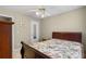 Well-lit bedroom with floral patterned bedding, ceiling fan, and carpet at 1256 Melrose Forrest Ln, Lawrenceville, GA 30045