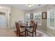 Sun-filled breakfast nook with a wooden table, four chairs, and large windows at 1256 Melrose Forrest Ln, Lawrenceville, GA 30045