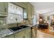 The kitchen features a black double sink, granite counters, and green backsplash at 1256 Melrose Forrest Ln, Lawrenceville, GA 30045