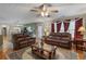 Open-concept living room with a kitchen in the background and leather furniture at 1256 Melrose Forrest Ln, Lawrenceville, GA 30045