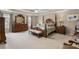 The main bedroom is adorned with wood furniture, neutral carpet, and a tray ceiling at 1256 Melrose Forrest Ln, Lawrenceville, GA 30045