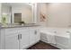 Bathroom featuring granite countertop vanity, white cabinets, and soaking tub, perfect for relaxation at 1508 Burberry Aly, Marietta, GA 30008