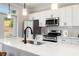 White kitchen with quartz countertop and stainless steel appliances at 1508 Burberry Aly, Marietta, GA 30008