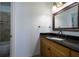 Bathroom featuring granite countertop, framed mirror, wood cabinets, and walk-in tiled shower at 2986 Nestle Creek Dr, Marietta, GA 30062