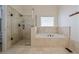 This bathroom features a soaking tub, glass enclosed shower, tile flooring and a bright window at 2986 Nestle Creek Dr, Marietta, GA 30062