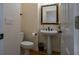 Powder room with pedestal sink, toilet, and ornate mirror at 2986 Nestle Creek Dr, Marietta, GA 30062