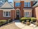 Elegant home entrance with a decorative door, manicured bushes, and a well-maintained brick facade at 2986 Nestle Creek Dr, Marietta, GA 30062