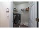 Compact laundry area featuring a side-by-side washer and dryer unit with shelving for storage at 2986 Nestle Creek Dr, Marietta, GA 30062