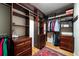 This walk-in closet features custom wood shelves and drawers, hanging rods, hardwood floors and a decorative rug at 2986 Nestle Creek Dr, Marietta, GA 30062