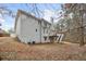 Back exterior with a deck and patio surrounded by mature trees, offering a private outdoor space at 69 New Brunswick Ct, Suwanee, GA 30024