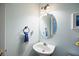 Charming powder room featuring an oval mirror and pedestal sink with a soft blue color scheme at 69 New Brunswick Ct, Suwanee, GA 30024