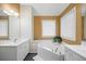 Corner tub with jets, double sinks and bright lighting in spacious bathroom at 69 New Brunswick Ct, Suwanee, GA 30024