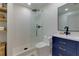 Well-lit bathroom with a walk-in shower, a blue vanity, and a sleek mirror at 8404 Majors Rd, Cumming, GA 30041