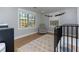 Bright Bedroom with a glider, a black crib, neutral decor, and large windows overlooking the backyard at 8404 Majors Rd, Cumming, GA 30041