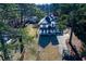 An aerial view of a charming two-story home with a well-manicured lawn and mature trees at 8404 Majors Rd, Cumming, GA 30041