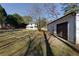 View of the house behind the detached white garage with a dark brown door and a large grassy area at 8404 Majors Rd, Cumming, GA 30041