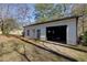 Exterior view of detached white garage featuring a car inside and side door at 8404 Majors Rd, Cumming, GA 30041