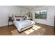 Sunlit bedroom featuring a cozy bed with decorative pillows, a stylish rug, and large windows at 8404 Majors Rd, Cumming, GA 30041