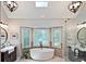 Bright bathroom with a soaking tub in front of a bay window, and dual vanities at 1590 Greyson Rdg, Marietta, GA 30062