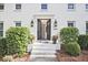 Inviting front entrance with black double doors, classic sconces, and landscaped greenery at 1590 Greyson Rdg, Marietta, GA 30062