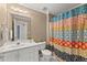 Bright bathroom with a white vanity, toilet, mirror, and patterned shower curtain at 3595 Ansley Park Dr, Suwanee, GA 30024