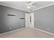 A well-lit bedroom features neutral carpet, gray walls, and a white ceiling fan at 3595 Ansley Park Dr, Suwanee, GA 30024