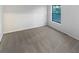 Empty bedroom with neutral walls, grey carpet, a window, and electrical outlets at 4396 Shelley Nw Ln, Lilburn, GA 30047